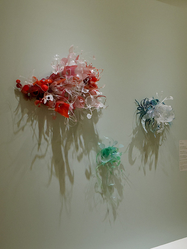 Photo of contemporary sculptures hanging in an art gallery.