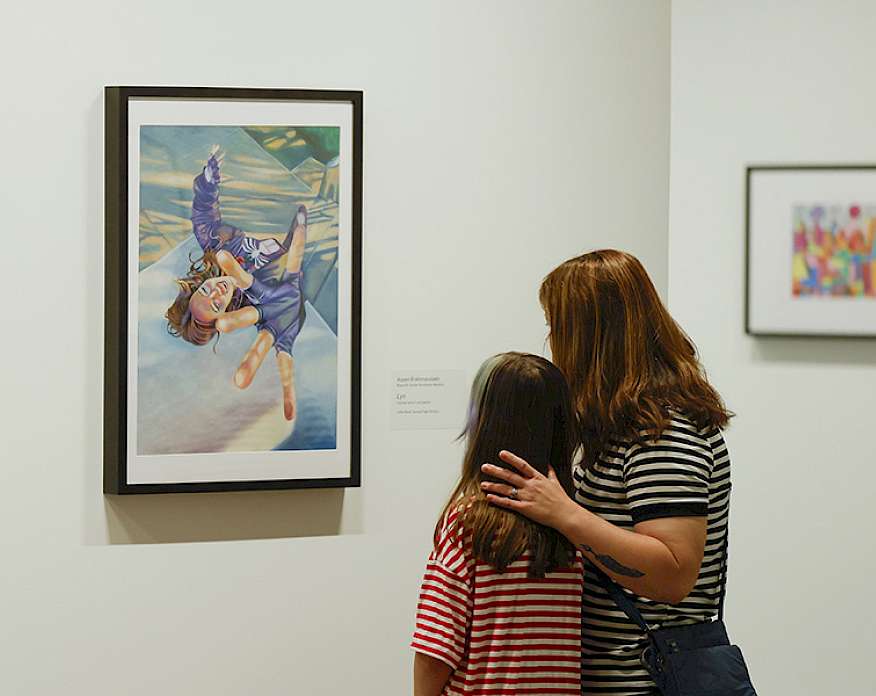 Photo of a mother and young daughter looking at art in an art gallery.