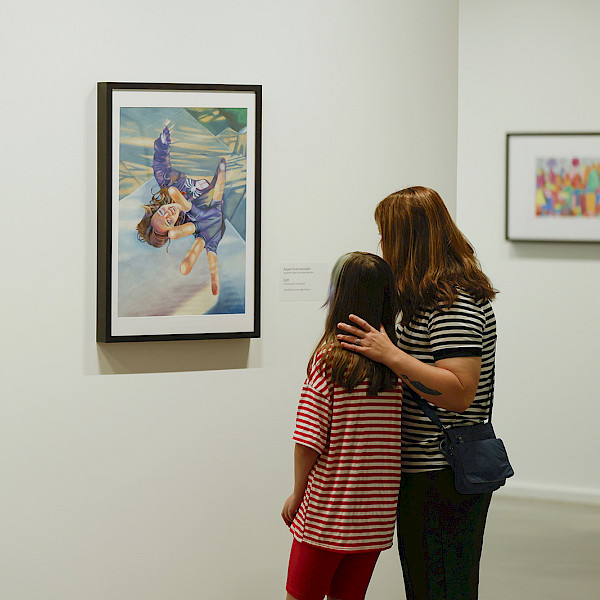 Photo of a mother and young daughter looking at art in an art gallery.